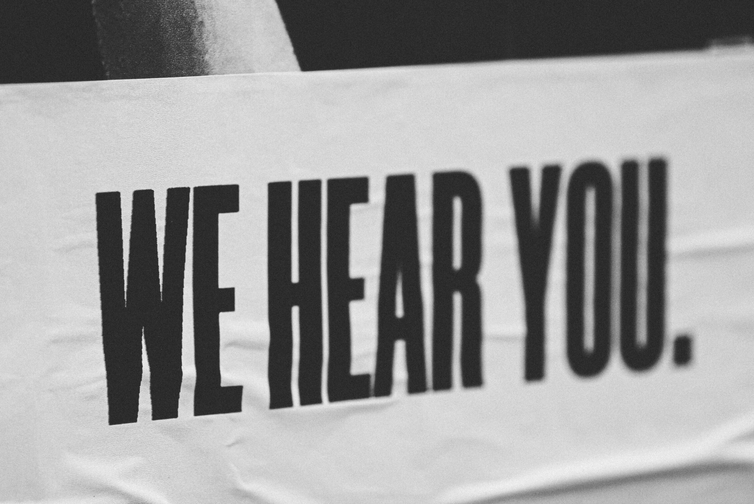 Image showing a white paper banner featuring the words WE HEAR YOU. in black capital letters. Image used to illustrate the use of surveys for a data driven business.